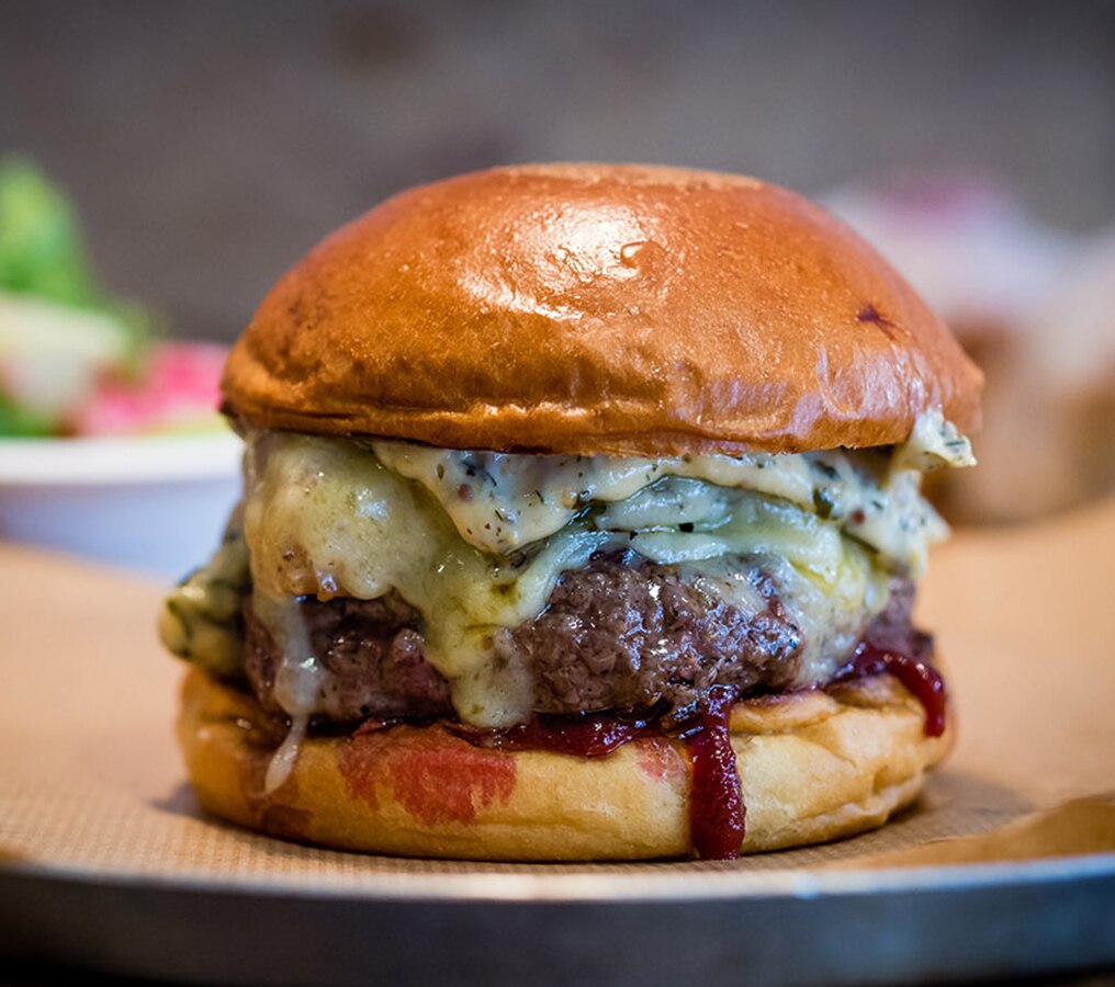 Peaky Blinders Manchester - Peaky Signature Burger ⁠ Ground brisket &  chunk steak patty, golden caramelised onions, black wax cheddar, shredded  lettuce and Peaky burger sauce. Perfectly paired with a cold pint
